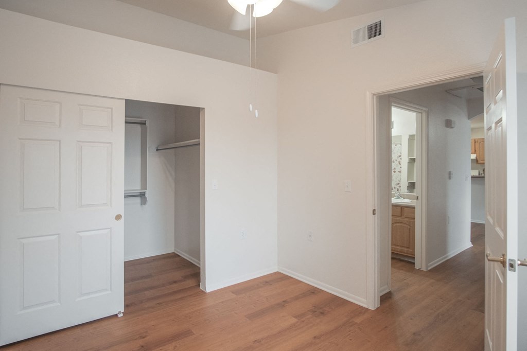 an empty living room with white walls and a wood floor