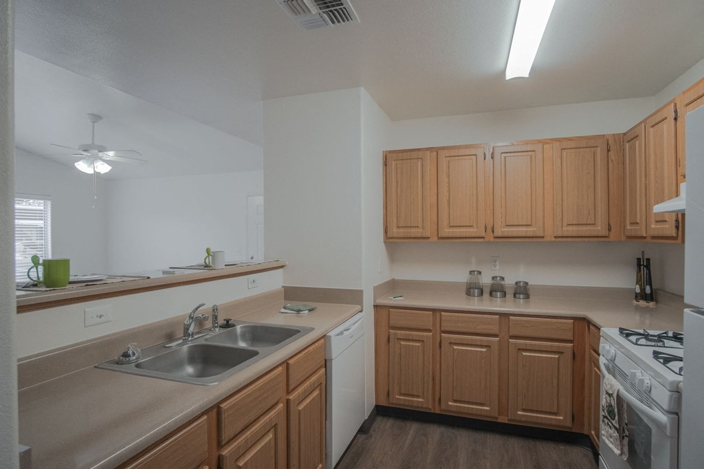 an empty kitchen with wooden cabinets and a sink