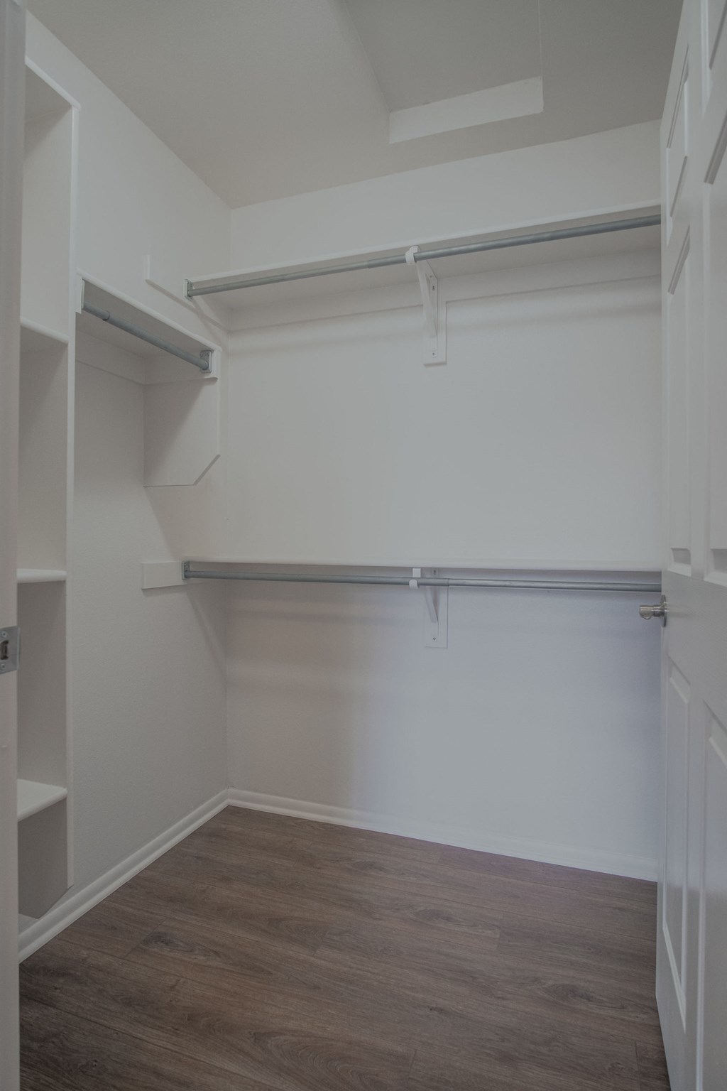 an empty room with a white wall and a wood floor