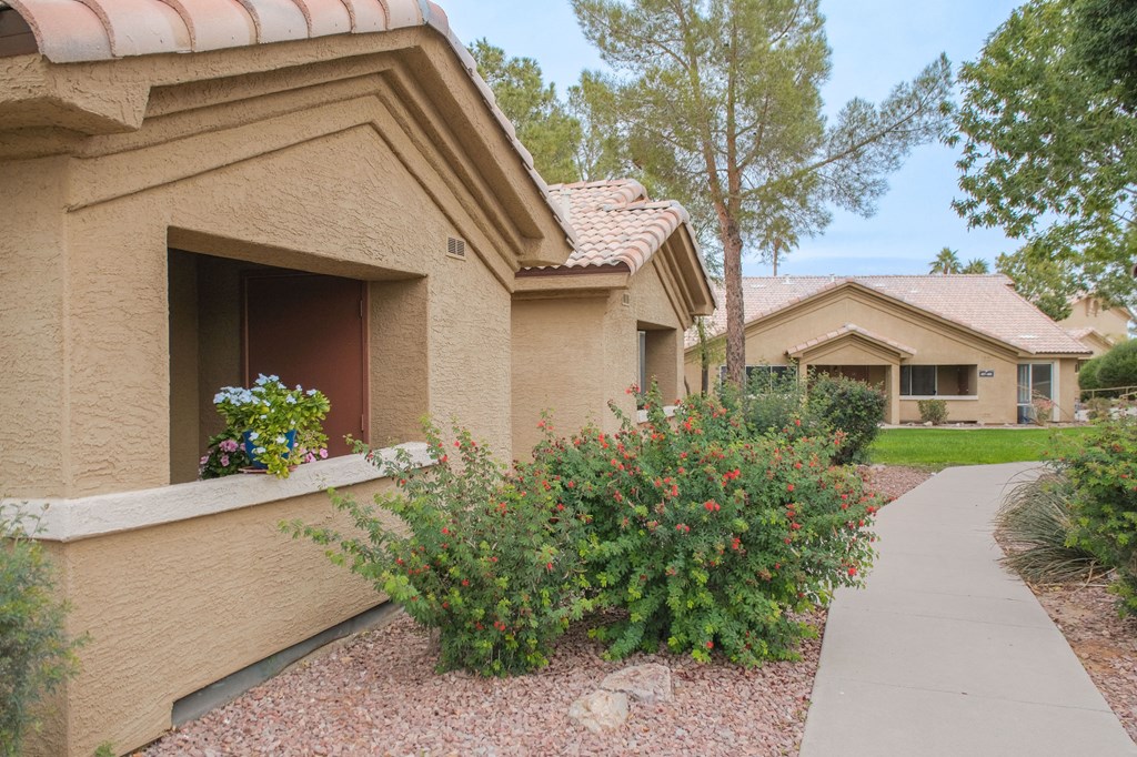 a house with a sidewalk in front of it and some flowers