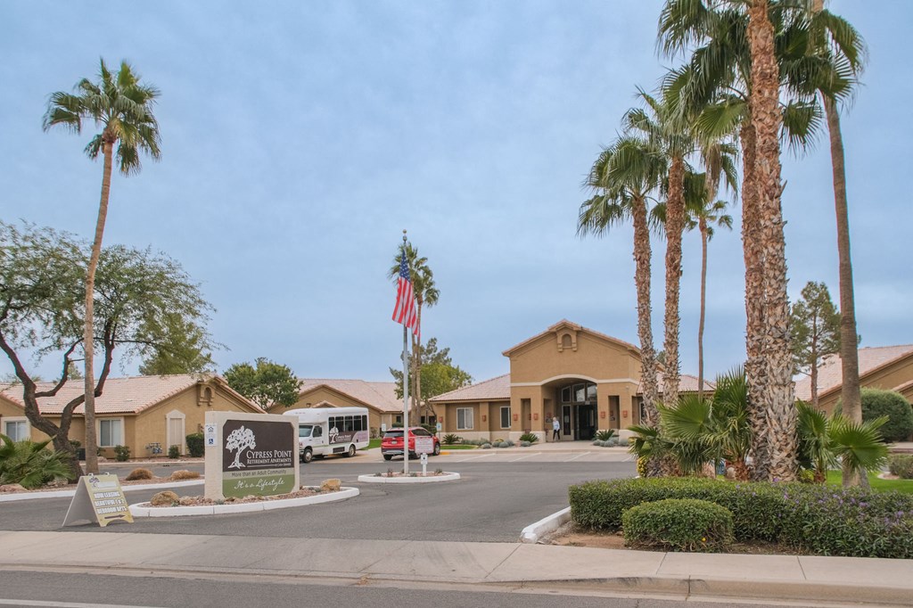 a building with a sign and palm trees in front of it