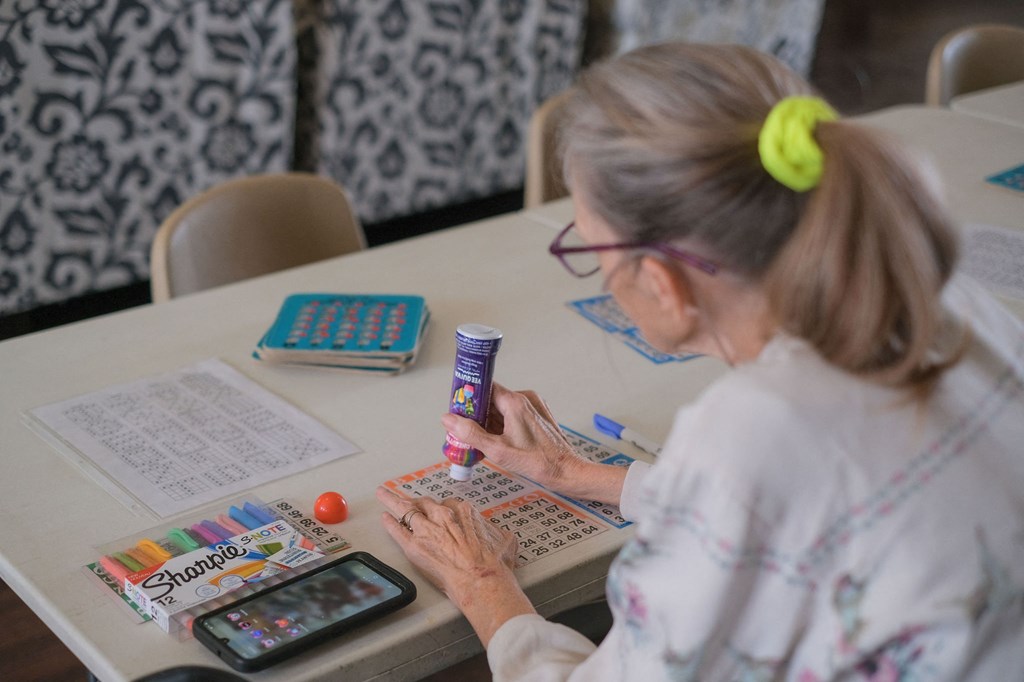 a woman sitting at a table using a calculator on a calculator