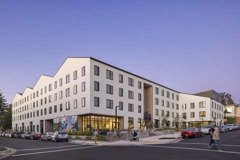 A modern building with a parking lot in front of it.