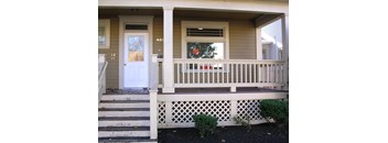 A house numbered 432 with a white door and a window with a red curtain.