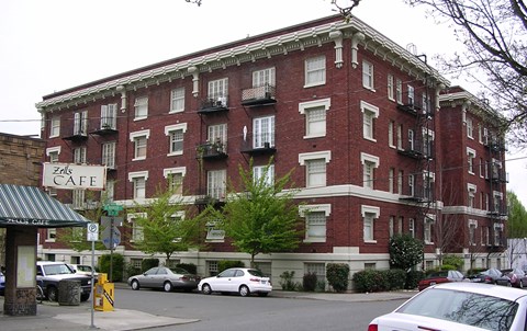 A red brick building with a green awning and a sign that says Zells Cafe.