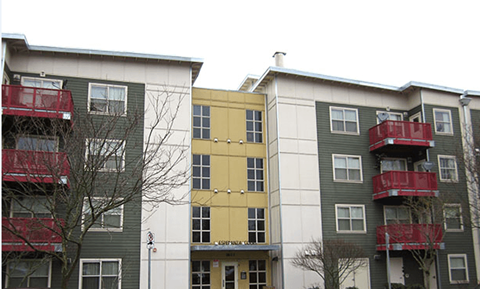 two buildings with red balconies and a yellow building in the middle