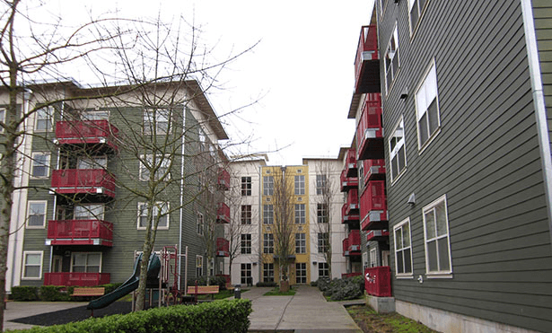 an apartment building with a sidewalk in front of it