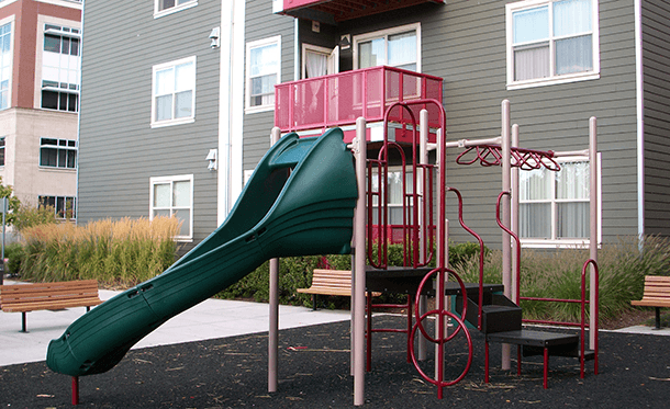 a playground with a slide in front of a building