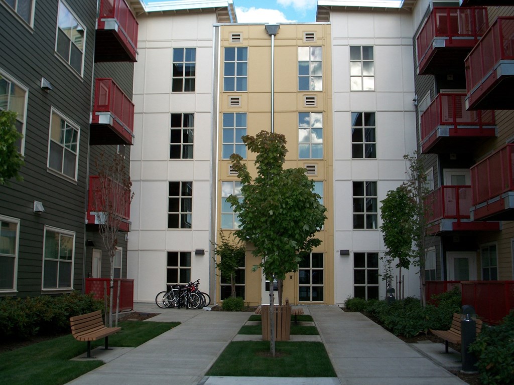 a view of the outside of an apartment building with a sidewalk and a bike