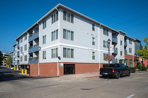 A black truck is parked in front of a multi-story building.