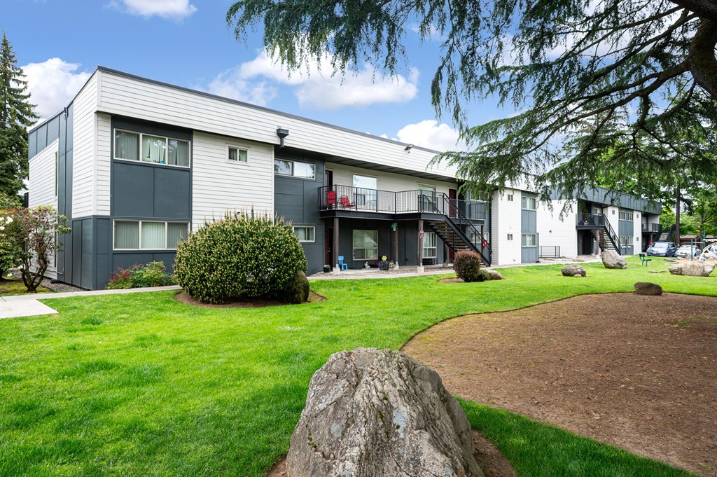 A large grey and white building with a red object on the balcony.