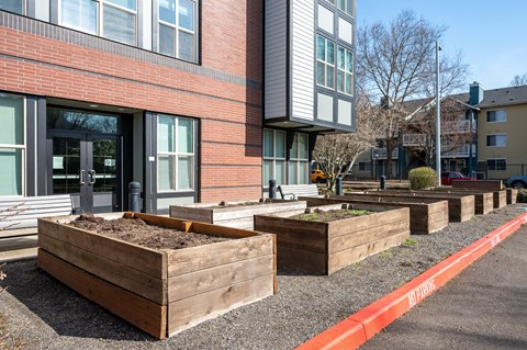 a row of wooden planters in front of a brick building
