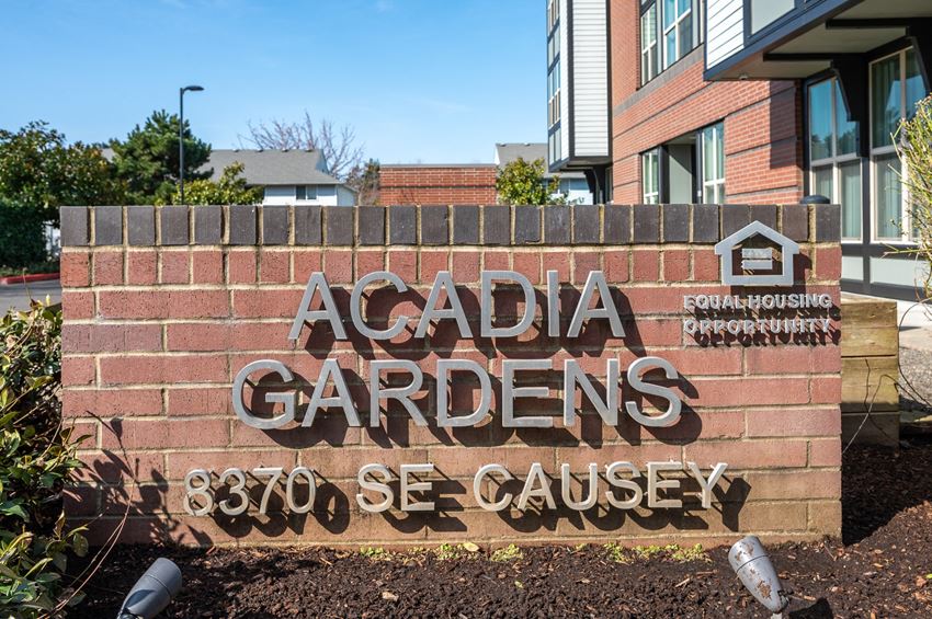 a sign for acadia gardens in front of a building