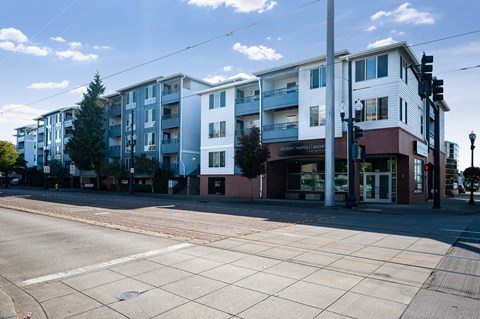 A street view of a city with buildings on the side and a crosswalk in the foreground.