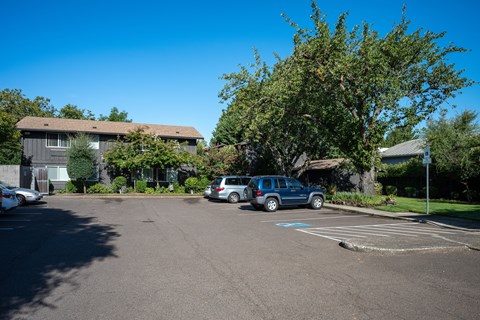 A parking lot with cars and a building in the background.
