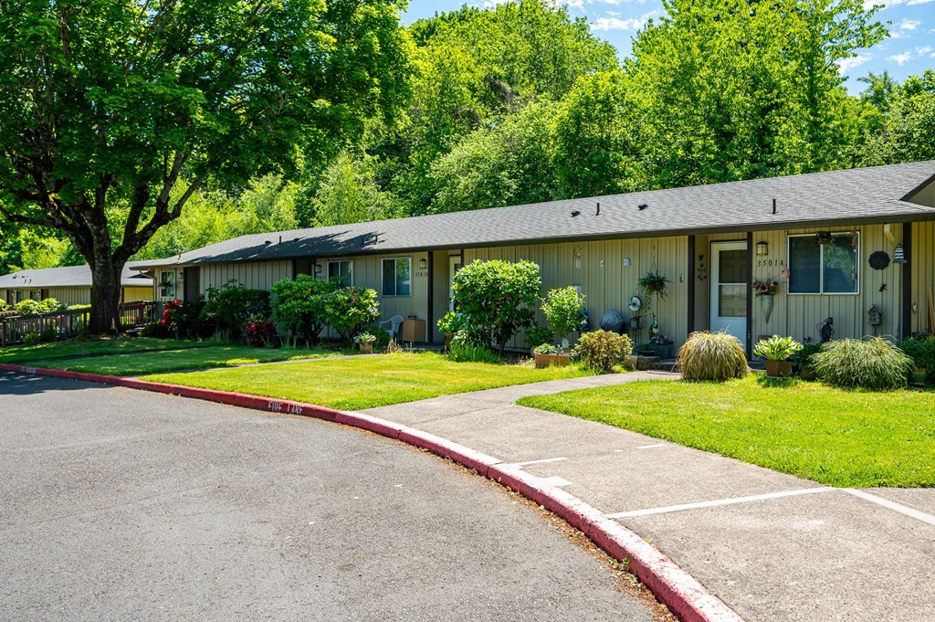 A row of houses with green trees in the background.