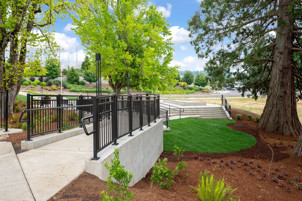 A black metal fence surrounds a green lawn.