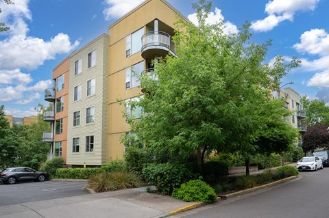 A modern apartment building with a balcony on the second floor.