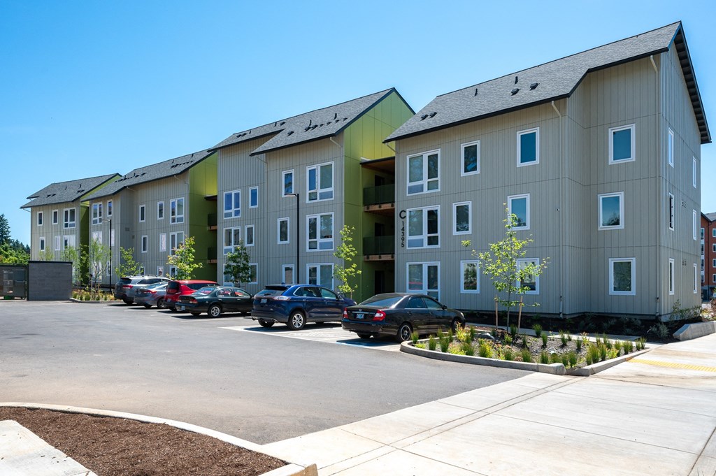 a large apartment building with cars parked in front of it