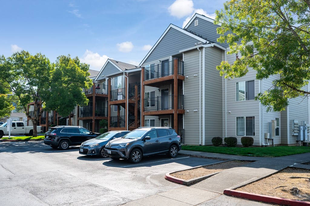 A parking lot with cars and apartment buildings.