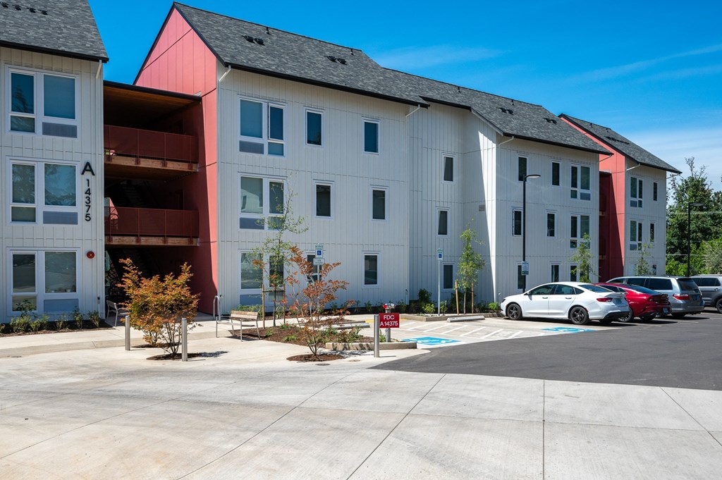 an apartment building with cars parked in front of it