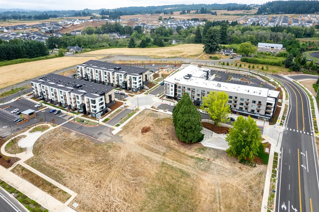 A large open field with apartment buildings in the distance.