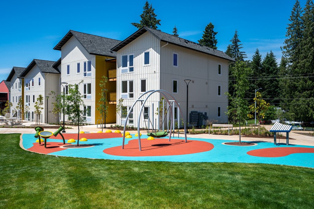 an empty playground in front of an apartment building