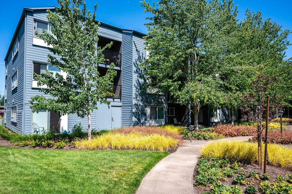 a sidewalk in front of a building with trees