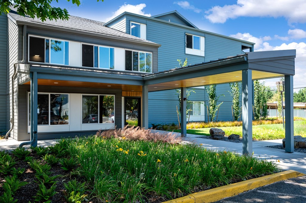 the front of a blue house with windows and a covered porch