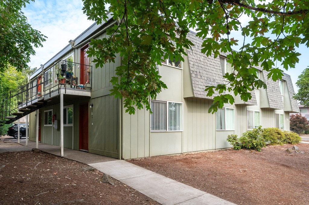 the exterior of a building with a balcony and a sidewalk