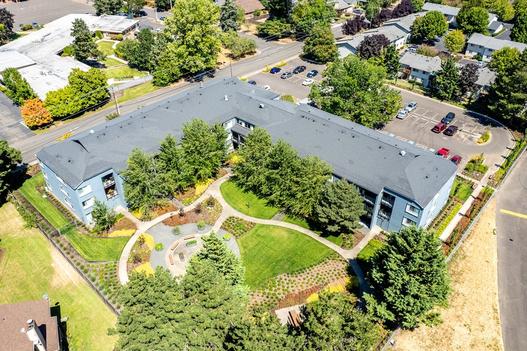 an aerial view of a building surrounded by trees and a park
