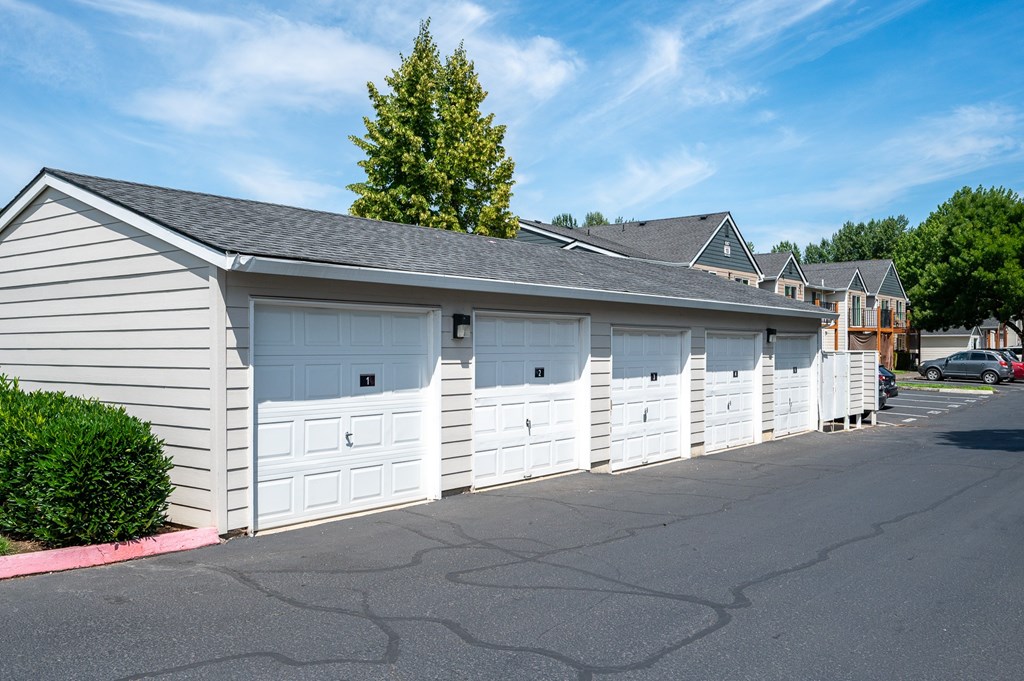 A row of garages with a tree in the background.