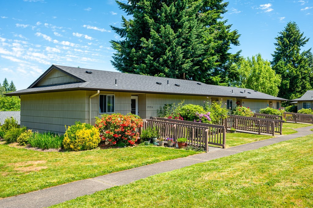 A house with a grey roof and a green lawn in front.