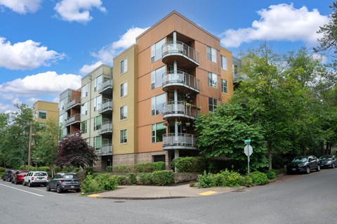 Apartment building with cars parked in front.