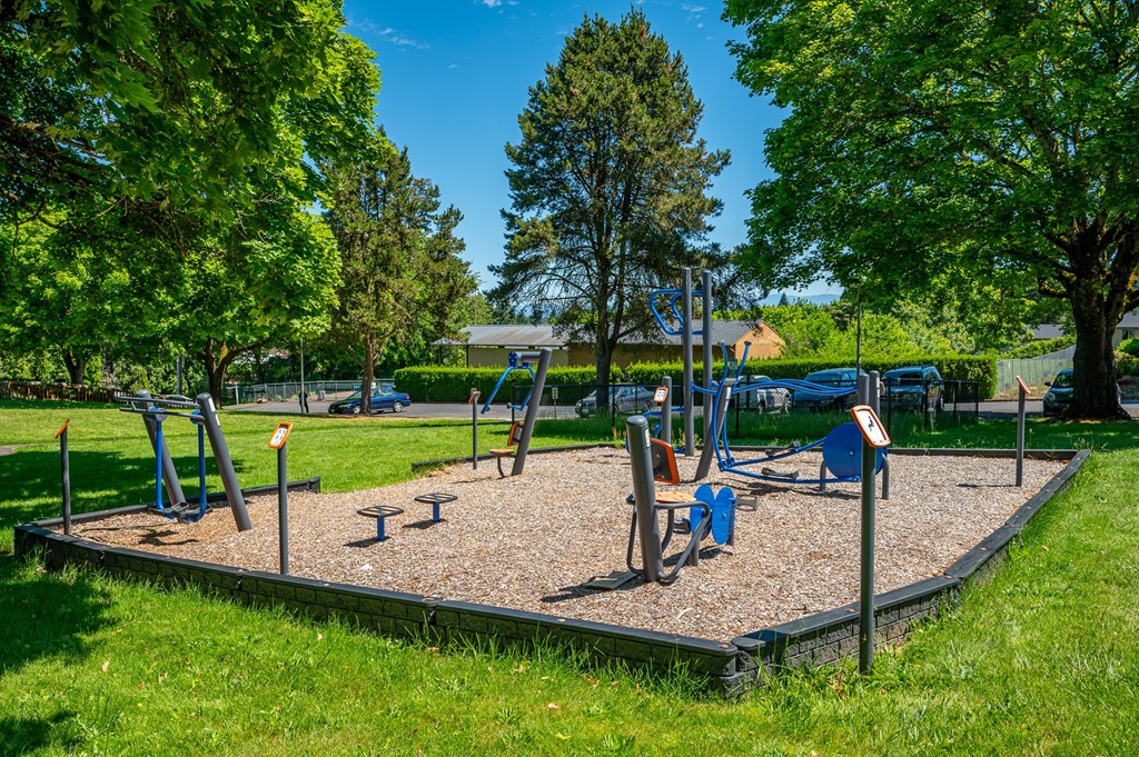 A playground with a seesaw, swings, and a slide.