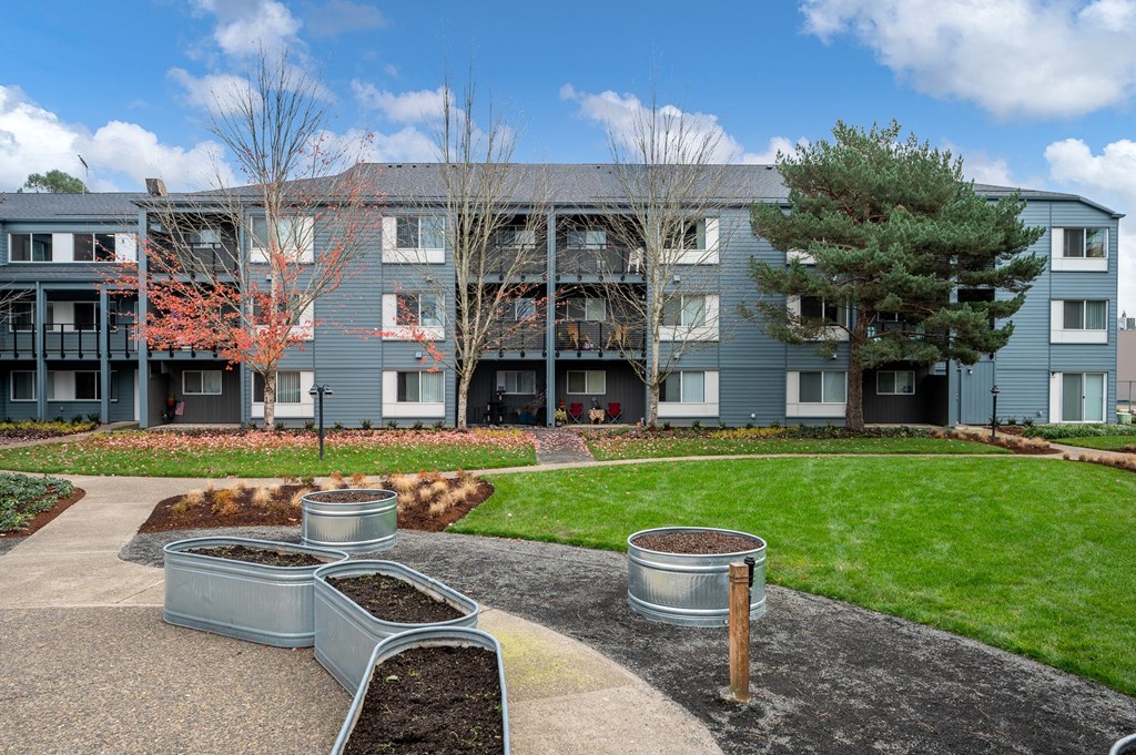 an exterior view of an apartment building with a courtyard and benches
