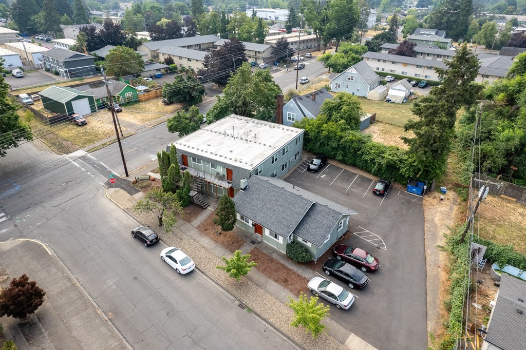 an aerial view of a building with cars parked in a parking lot