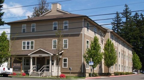 A brown building with a white truck parked in front.