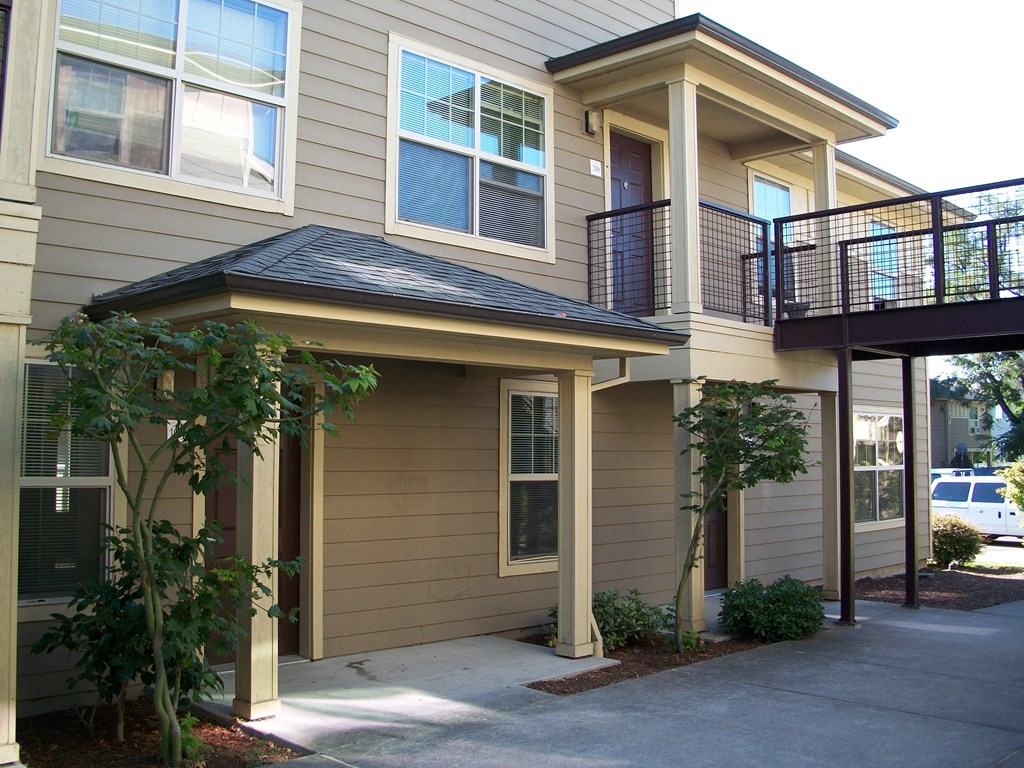 the front of the house has a walkway and a balcony