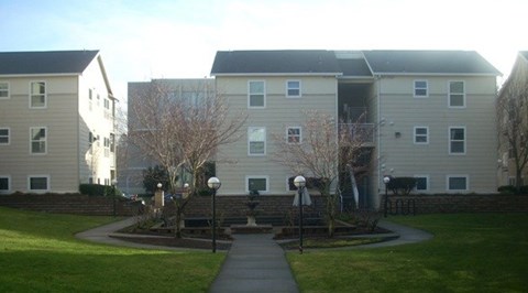 Apartment complex with a walkway in front.