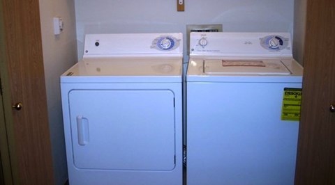 A white washing machine and dryer in a small room.