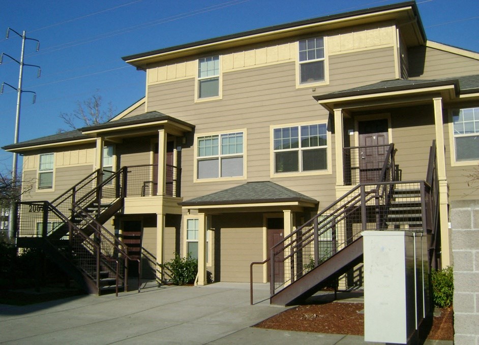 a tan house with stairs and a sidewalk
