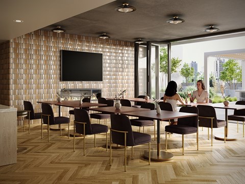 A conference room with a long table and chairs, a television on the wall, and a view of the city outside the windows.