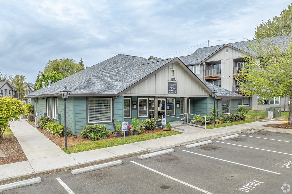 A parking lot in front of a building with a sign that says "Office".