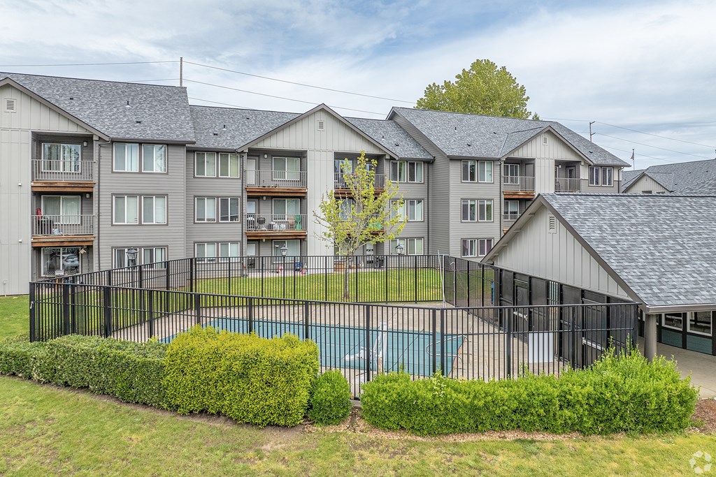 A large apartment complex with a pool in the foreground.