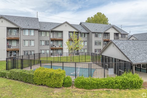 A large apartment complex with a pool in the foreground.