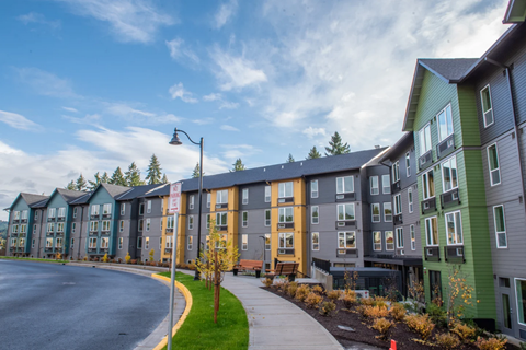 a row of apartment buildings on a street with a road
