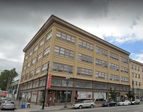 A building with a red sign on the ground floor.