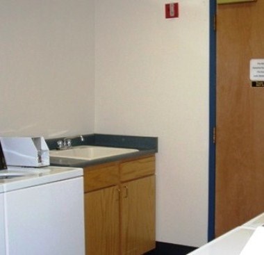 A white washing machine is in a small laundry room.