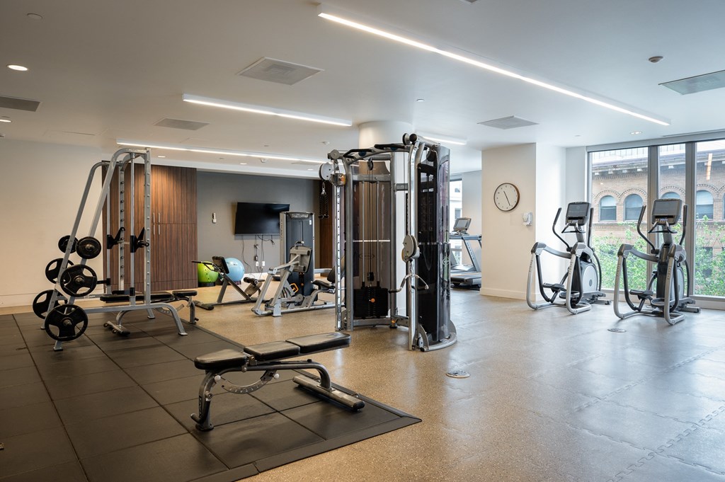 a gym with weights and cardio equipment in a building